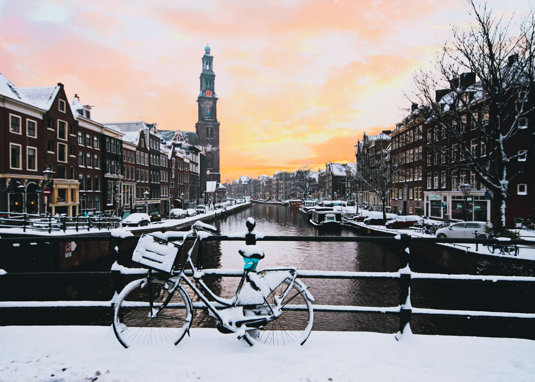 Amsterdam canal and streets covered in snow at sunrise 